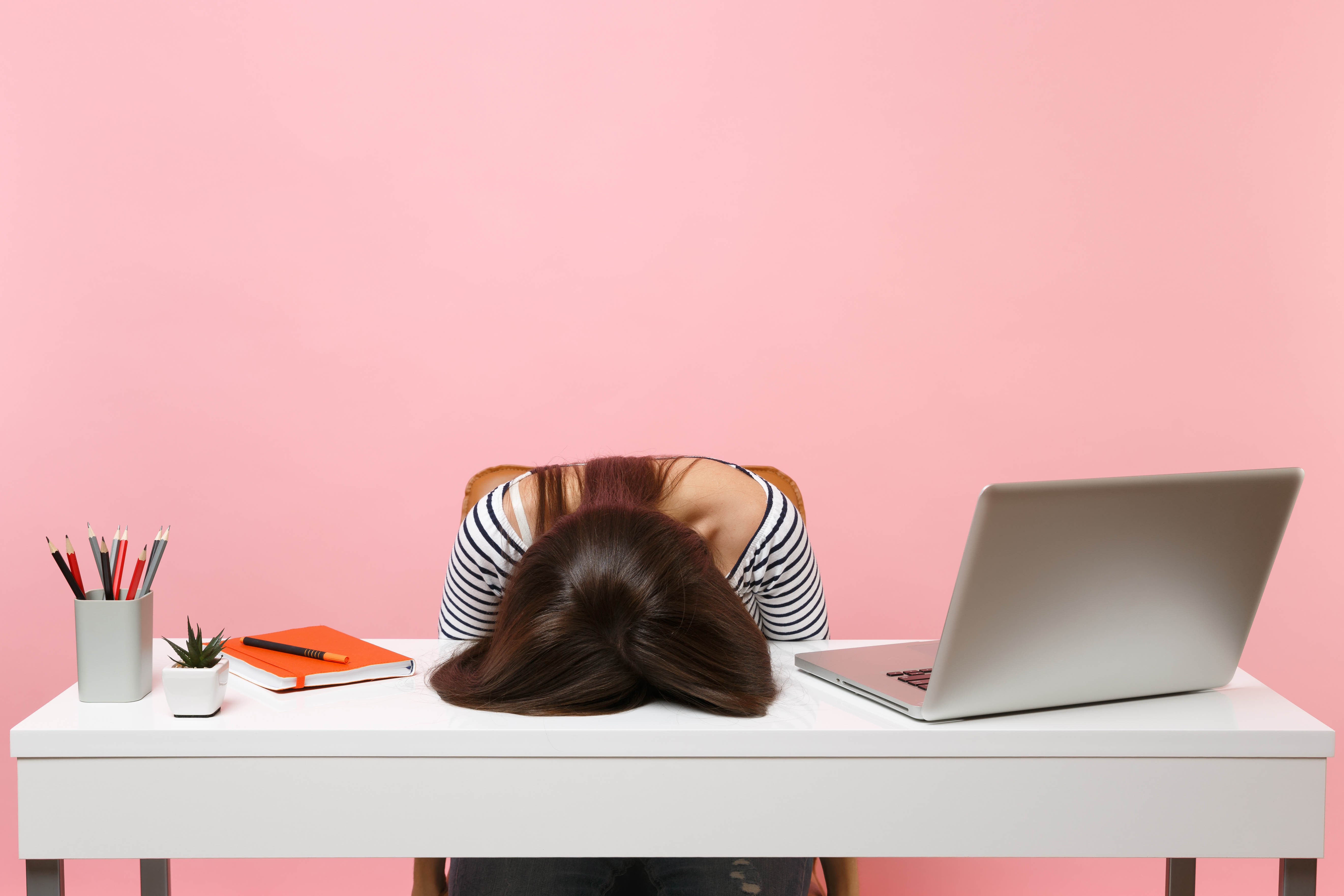 Exhausted girl with her head down on her desk